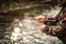 Close-up view of the hands of a fly fisherman working the line and the fishing rod