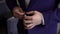 Close-up view of the hands of the groom buttoning the wedding jacket.