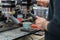 Close-up view hands of professional barista working in coffee house preparing espresso, waiting for coffee machine to