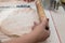 Close-up view of the hands with rolling pin making homemade potstickers.