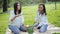 Close-up view of happy and soapy girls sitting on bedspread over grass in park and cutting and eating watermelon in