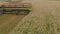 A close-up view of a harvester cutting wheat in a field.