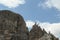 A close up view on high and sharp peaks of Dolomites in Italy.  The sky is full of soft clouds. Lots of lose stones and pebbles.