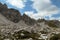 A close up view on high and sharp peaks of Dolomites in Italy.  The sky is full of soft clouds. Lots of lose stones and pebbles.