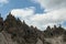 A close up view on high and sharp peaks of Dolomites in Italy.  The sky is full of soft clouds. Lots of lose stones and pebbles.