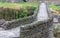 Close up view of historic stone bridge from Roman times in a secluded mountain valley