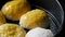 Close up view of homemade baking on a baking sheet, female baker greases the balls from the dough with an egg so that