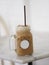 Close up view of ice cubes in cold brewed coffee Cappuccino in plastic cup put on bamboo wooden desk blurred background, drink