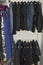 Close up view of interior of built-in wardrobe. Blue and black jeans on white hangers. Cloth organizer