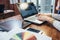 Close-up view of interior designer workspace with laptop, graphic tablet, phone and color palette on desk