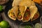 Close-up view of juicy tasty tacos with beef meat and vegetables on wooden background. Preparing traditional dish mexican cuisine