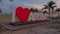 Close up view of large white letters I love Aruba at sunset in center of Oranjestad, capital of Aruba. Big red heart replaces word