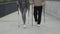 Close up view of the legs of the mature couple doing nordic walking. Elderly family with trekking poles walking in the