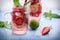 Close up view on lime and strawberry detox drink in glass mason jars on a blue background 8