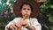 Close up view of little charming boy in straw hat playing on wooden music instrument in green garden. Happy child plays on flute