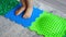 Close up view of Little girl walks on a massage mat. Toddler baby foot massage mat. Exercises for legs orthopedic