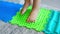 Close up view of Little girl walks on a massage mat. Toddler baby foot massage mat. Exercises for legs orthopedic