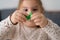 Close up view of the little kid girl sitting at the table and toying with colored figures