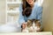 Close up view lovely cat is fun played by pretty Asian woman sit on sofa with day light and she look happy by smiling and cat also