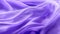 A close-up view of a luxurious purple satin fabric, elegantly draped and capturing the smooth texture and gentle folds,