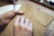 Close-up view of male hands holding brown envelope with coffee at the wooden desk