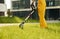 Close up view. Man cut the grass with lawn mover outdoors in the yard