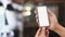 Close up view of man hands holding mock up smart phone with cafe blurred background.