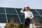 Close up view of man\'s hand that is holding light bult in front of solar panel