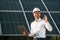 Close up view of man\'s hand that is holding light bult in front of solar panel