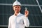 Close up view of man\'s hand that is holding light bult in front of solar panel