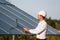 Close up view of man\'s hand that is holding light bult in front of solar panel