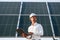 Close up view of man\'s hand that is holding light bult in front of solar panel