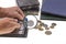 Close up view of man`s hand with magnifying glass and albums collection of ancient coins.