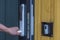 Close up view of man`s hand opening   entrance door with digital lock. Modern technology concept.