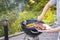 Close up view of man`s hands grilling food on coal grill.