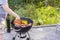 Close up view of man`s hands grilling food on coal grill.