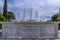 Close up view of the marble fountain gushing water in front of the Zappeion Hall neo-classical building in the National Garden par