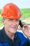 Close-up view of mature manual worker in hardhat calling on the phone