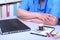 Close-up view of medical doctor working table. Laptop, stethoscope, assorted pils and patient information form