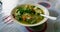 The close up view of the mixed vegetables soup with soo hoon noodles in a bowl