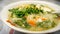 The close up view of the mixed vegetables soup with soo hoon noodles in a bowl