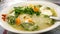 The close up view of the mixed vegetables soup with soo hoon noodles in a bowl