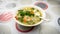 The close up view of the mixed vegetables soup with soo hoon noodles in a bowl