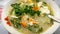 The close up view of the mixed vegetables soup with soo hoon noodles in a bowl