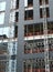 Close up view of a modern construction site with hoists running up the tall building with steel girders with black panels and wind