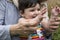 close-up view of mother and little baby teaching to clap in outdoor field