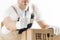 Close-up view of mover in uniform showing thumb up with cardboard boxes on white background. Relocation services worker