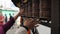 A close-up view of nepalese people spinning prayer wheels. Kathmandu Nepal. Hands. Candles and prayer flags in the