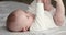 Close up view newborn baby in bodysuit lying on bed