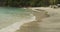 Close up view of ocean waves on tropical beach. Slow blue sea waves moving sand on the beach